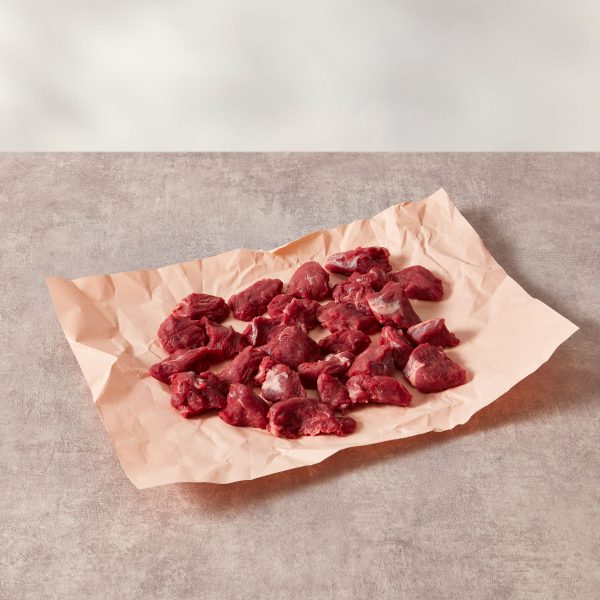 Diced stewing steak on pink butchery paper