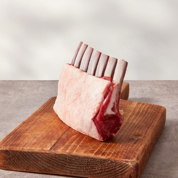 Trimmed rack of lamb on a wooden board
