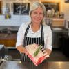 Female butcher holding a rack of lamb with rosemary on top