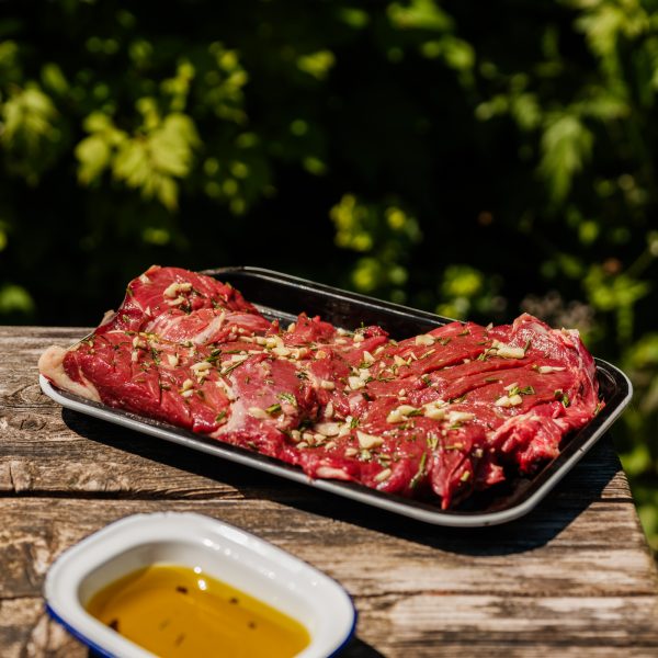 Marinated butterflied lamb on a tray for a bbq